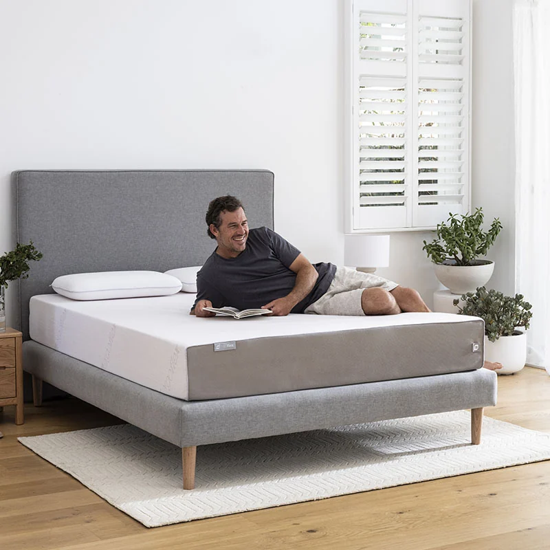 Modern mattress on a bed frame in a bright bedroom